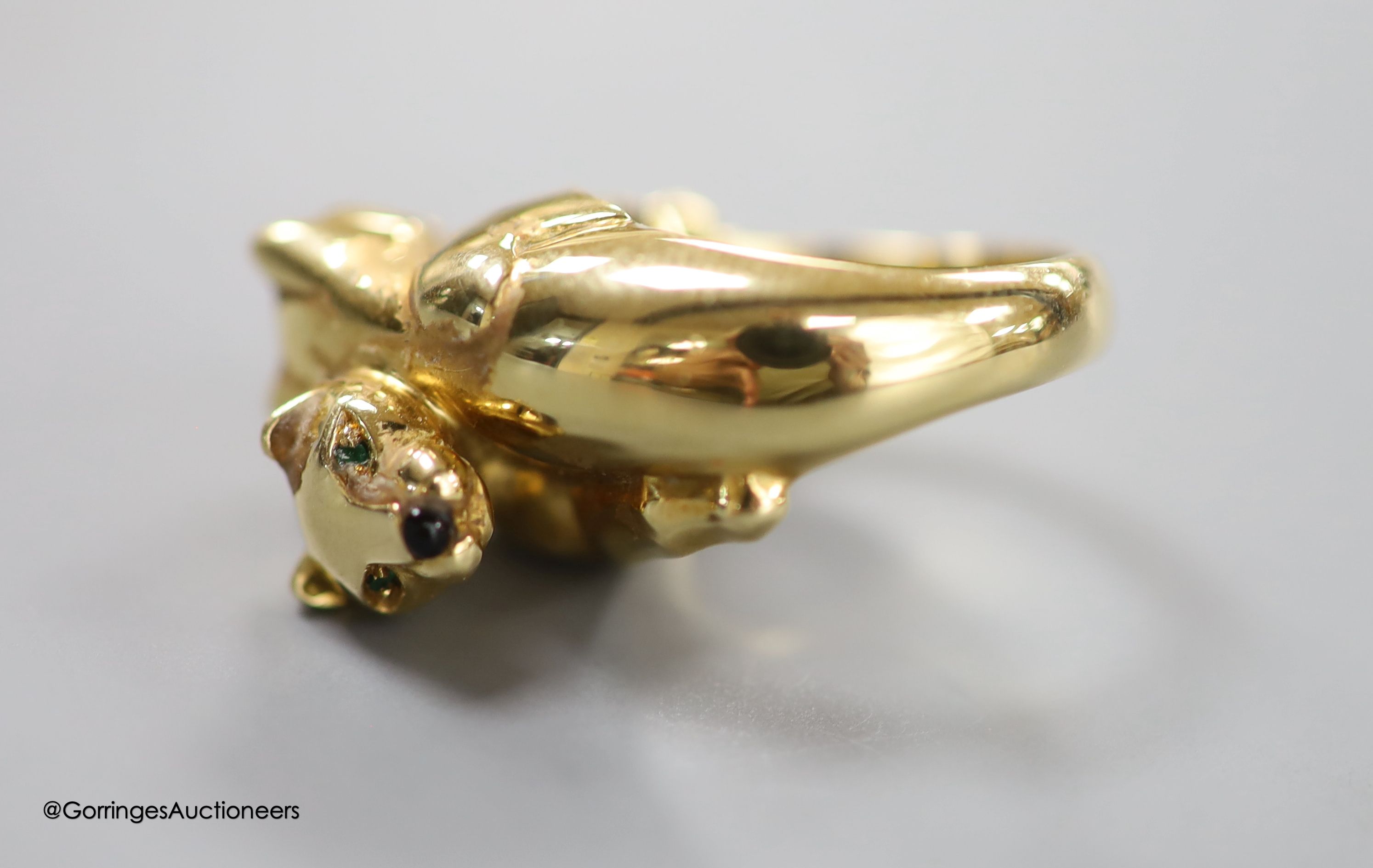 An early 1990's Cartier 18ct gold, black onyx and emerald set twin leopard's head crossover ring